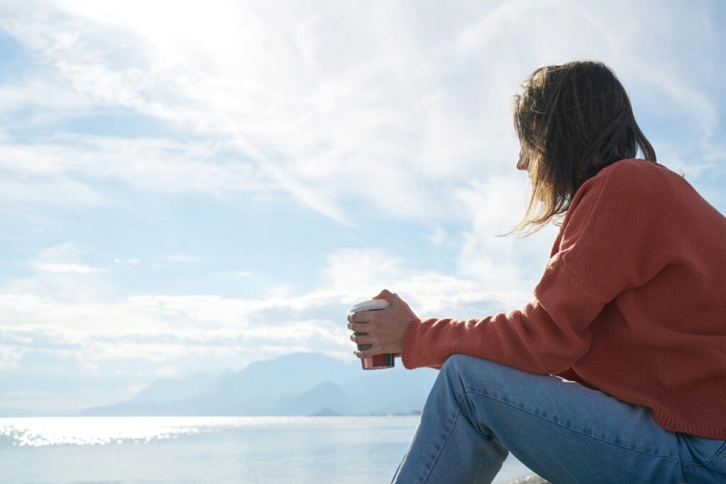 Person sitting by the sea in self reflection